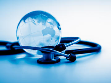 a glass globe of the earth and a stethoscope